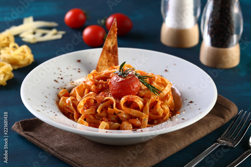 tagliatelle with tomato sauce with cheese on a wooden background photo