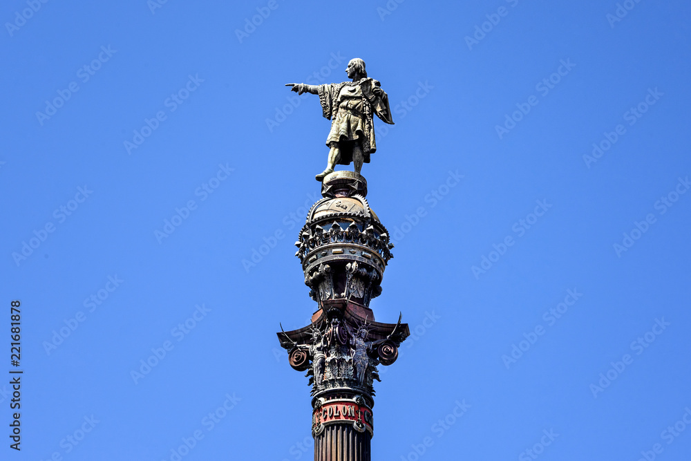 Spain, Barcelona: Detail close up of famous Columbus Monument (Monument de Colom) at the lower end of La Rambla in the city center of the Spanish town with blue sky - isolated on blue background.