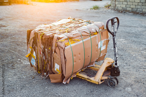 Hand-fork truck with stack of cardboard for recycling