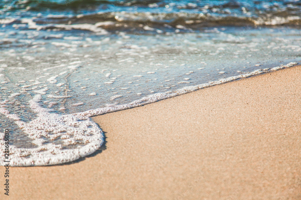 waves of pure azure water with white foam on yellow sand on a sunny day, close up blurry background waves of pure azure water with white foam on yellow sand on a sunny day, close up blurry background