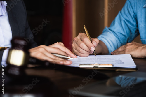 Close up of an executive hands holding a pen and indicating where to sign a contract at office photo