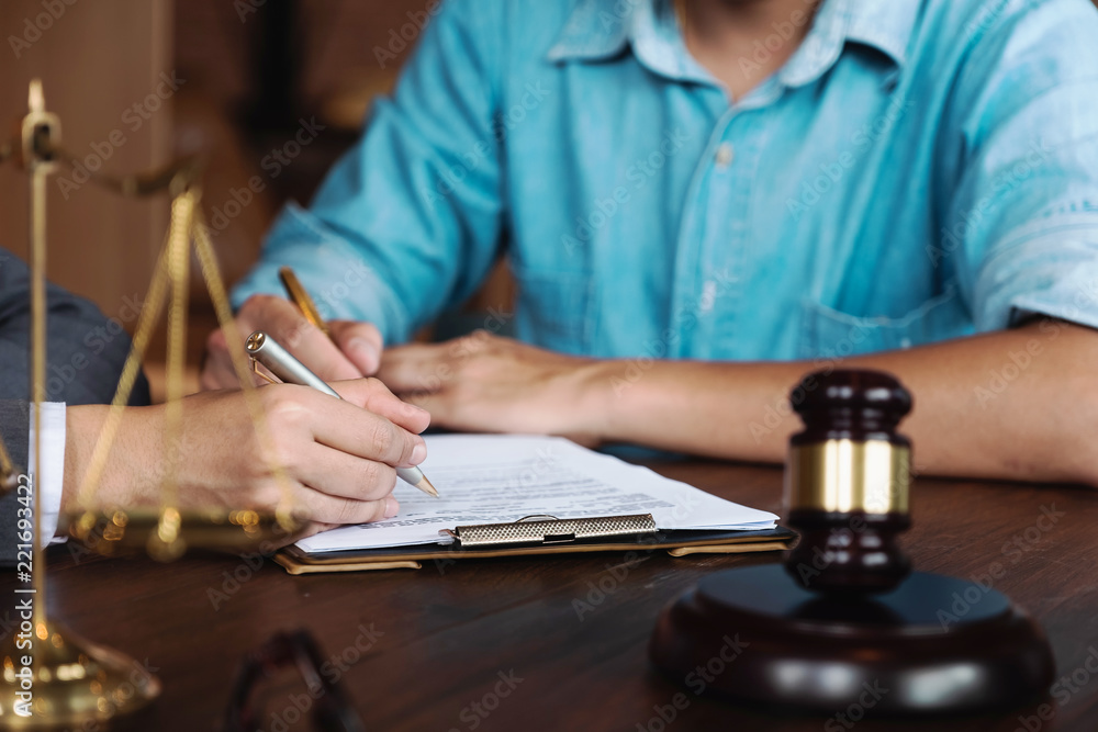 Judge gavel with Justice lawyers having team meeting at law firm in background. Notary with client in office Judge gavel with Justice lawyers having team meeting at law firm in background. Notary with client in office