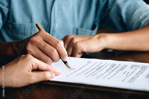 Business man signing a contract. Close up of two business partners signing a document for agreement contract - business etiquette, congratulation, merger and acquisition concept