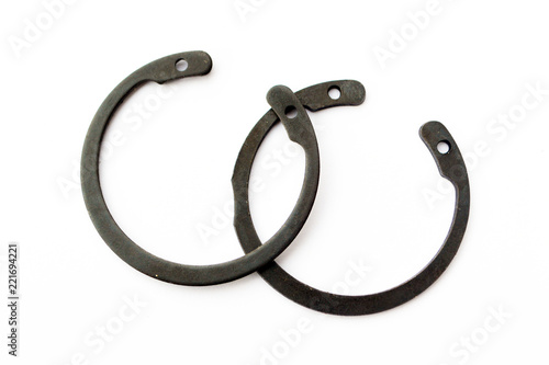 Fotografía Black circlip retaining rings scattered on a white background