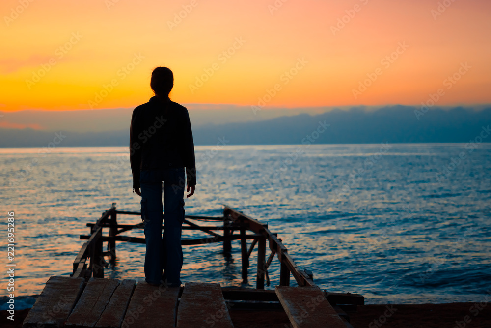 girl on the dock at sunset