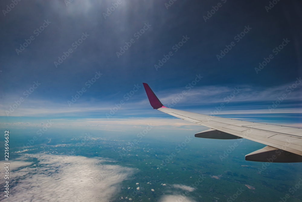 Fototapeta premium Looking through window aircraft during flight in wing with a blue sky