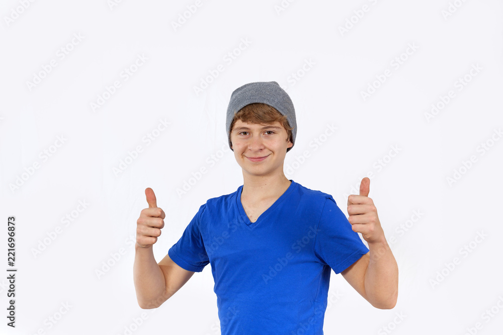 portrait of teenage boy with cap showing thumbs up sign portrait of teenage boy with cap showing thumbs up sign