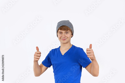 portrait of teenage boy with cap showing thumbs up sign