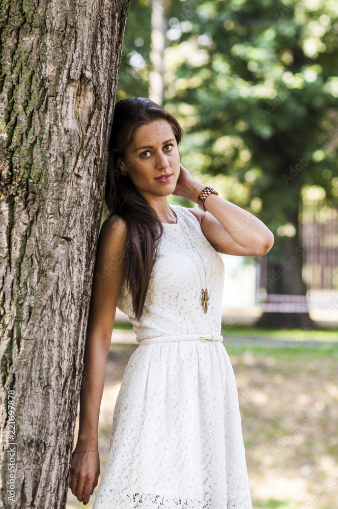 Young girl in a white dress in a summer park

