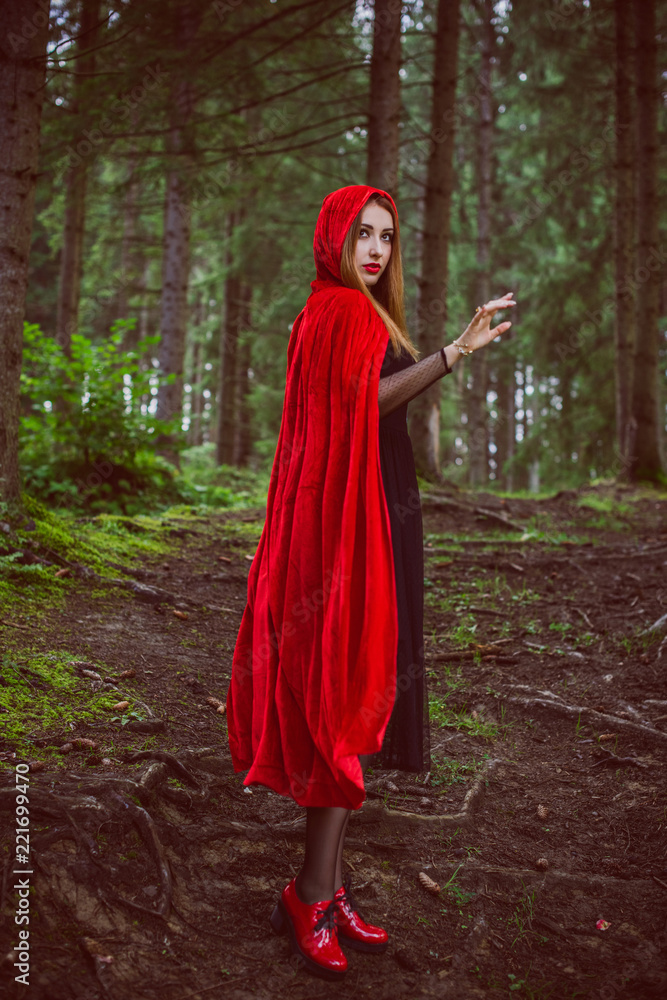 Concept of Halloween. Beautiful and simple costume of little red hood. Mysterious hooded figure in misty forest. Girl in red raincoat. Cosplay Fairy Tale Little Red Riding Hood Concept of Halloween. Beautiful and simple costume of little red hood. Mysterious hooded figure in misty forest. Girl in red raincoat. Cosplay Fairy Tale Little Red Riding Hood