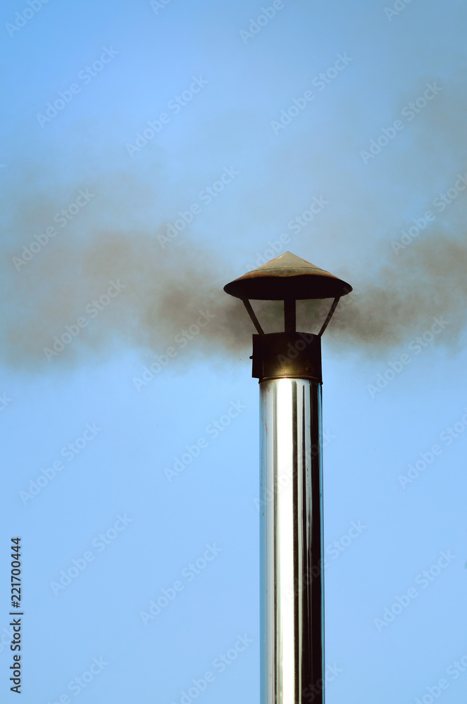 Black smoke comes from an iron pipe, close-up, vertical photograph. Black smoke comes from an iron pipe, close-up, vertical photograph.