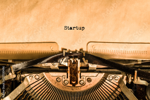 the word Startup printed on a piece of paper by a typewriter. retro objects.