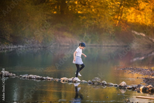 Little blonde girl on the riverside