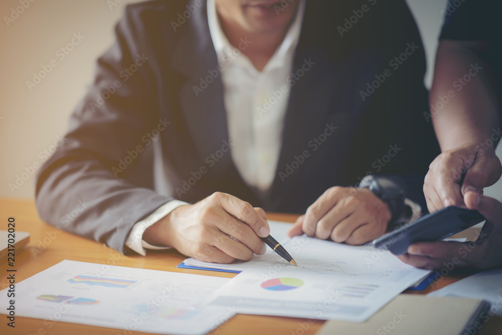 Businessmen use the calculator to calculate and analyze the comp Businessmen use the calculator to calculate and analyze the comp