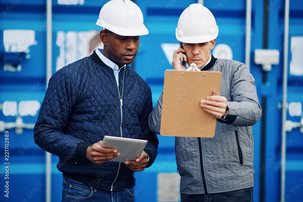 Two engineers checking inventory in a shipping yard