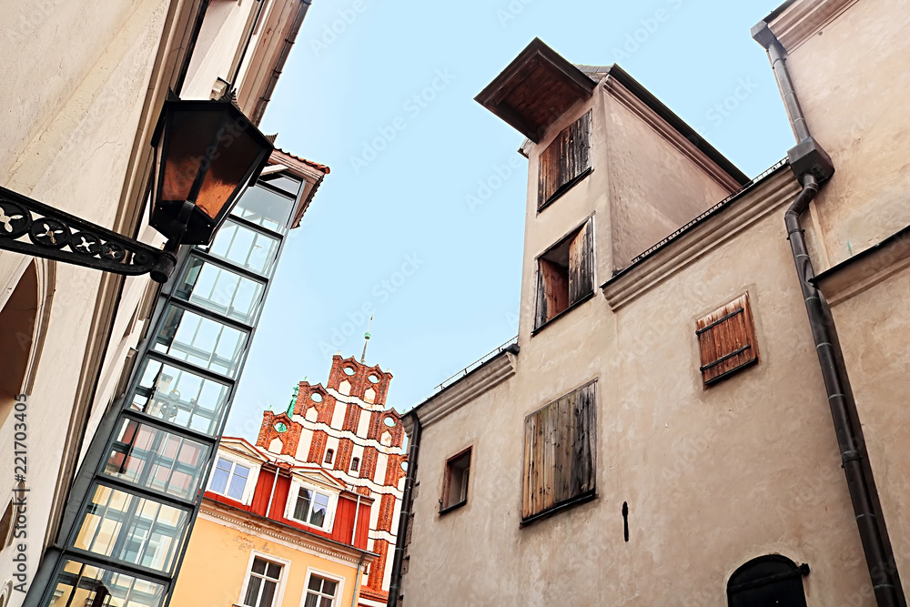 Naklejka premium View of Saint John's Church (red bulding) andold industrial building (left), Riga, Latvia