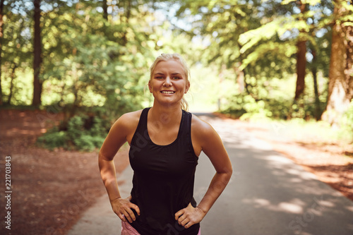 Smiling young woman in sportswear ready for her forest run