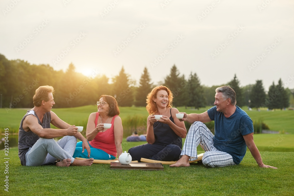 Group of friends meeting in the park for drinks. People having conversation in the park. Group of friends meeting in the park for drinks. People having conversation in the park.