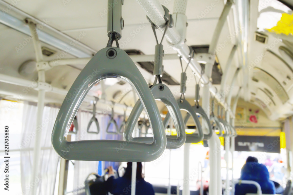 Row of Gray handle on ceiling for Standing passenger on the bus. Selective focus of Hand grip strap on public bus.