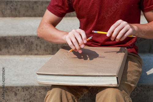 Photography Pencil or Pen tapping student using two pencils and a text book