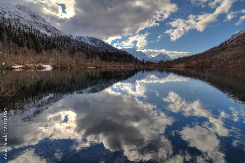 Kardyvach mountain lake with sky reflections. Scenic dramatic autumn sunset landscape. Sochi  Russia  Caucasus mountains