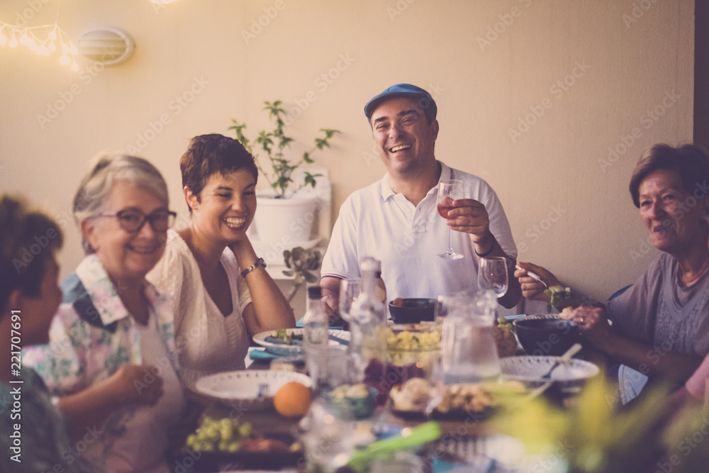 happy group of different ages people celebrating and having fun together in friendship at home or restaurant. cheering and toasting with cocktails and alchool. smile and enjoy the party with adult happy group of different ages people celebrating and having fun together in friendship at home or restaurant. cheering and toasting with cocktails and alchool. smile and enjoy the party with adult