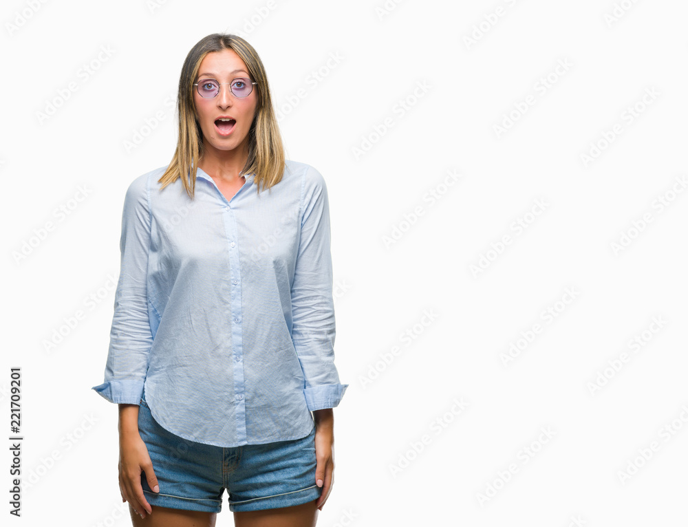 Obraz premium Young beautiful woman wearing sunglasses over isolated background afraid and shocked with surprise expression, fear and excited face.