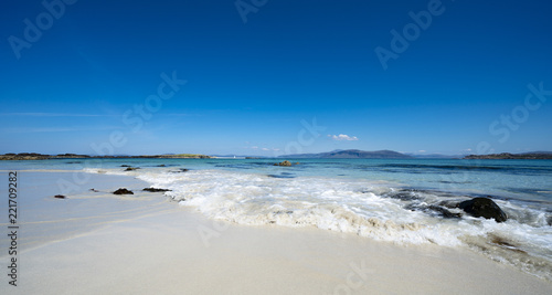 Waves on the beautiful white sands of the North Beach, Isle of Iona, Scotland, UK, on a sunny day