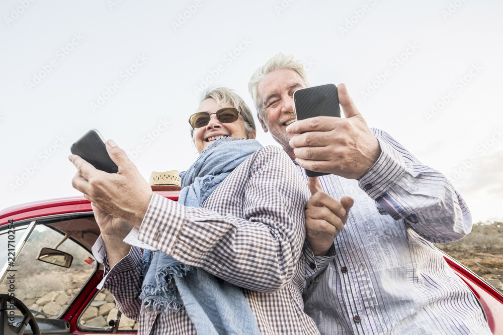 Φωτογραφία alternative point of view from the bottom for youthful senior couple caucasian people using smartphone to take pictures and connect to internet