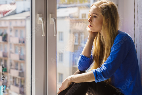 Sad depressed teen girl sitting on window sill Free Download Sad depressed teen girl sitting on window sill - GFXLoad