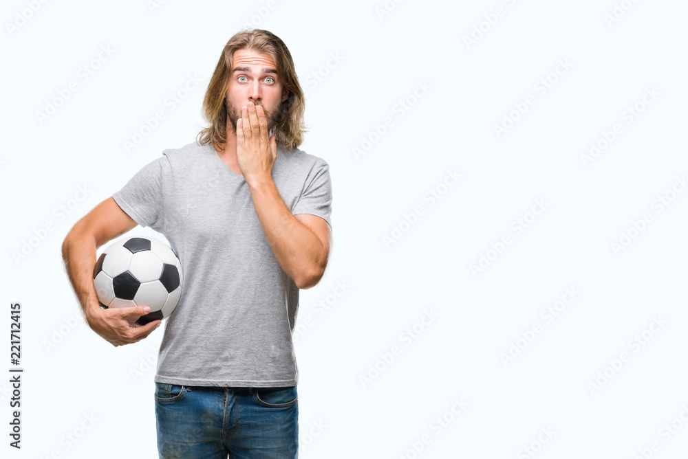 Young handsome man with long hair over isolated background holding football ball cover mouth with hand shocked with shame for mistake, expression of fear, scared in silence, secret concept