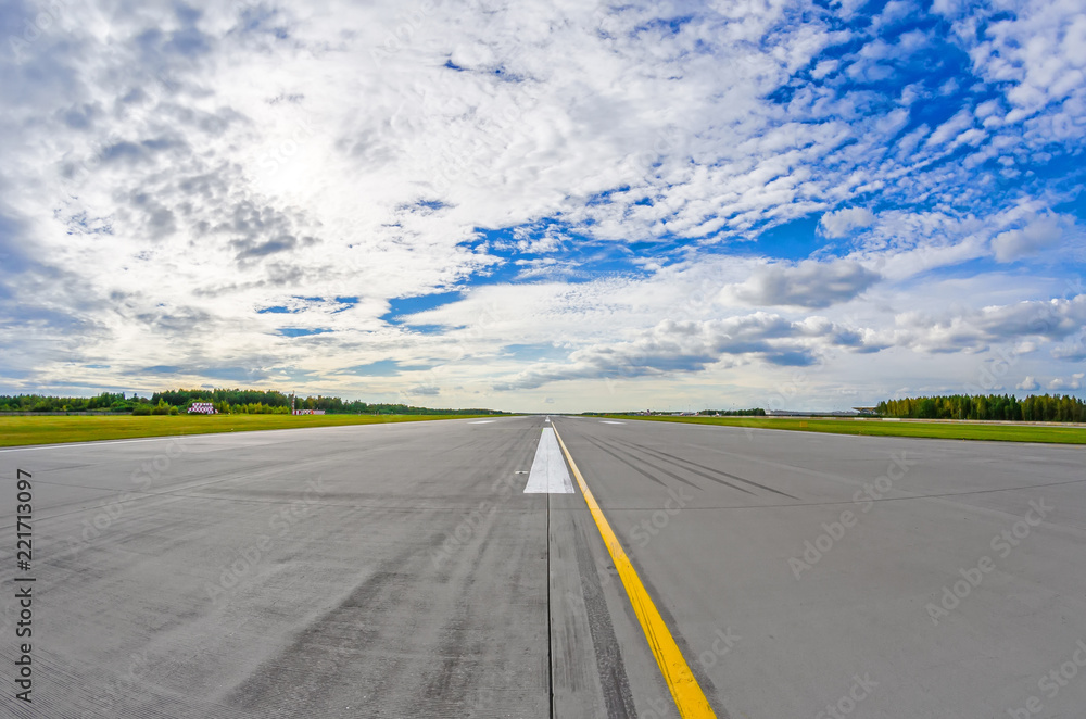 Airport runway to in horizon and picturesque clouds in the blue sky. Airport runway to in horizon and picturesque clouds in the blue sky.