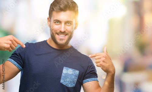 Young handsome man over isolated background looking confident with smile on face, pointing oneself with fingers proud and happy.