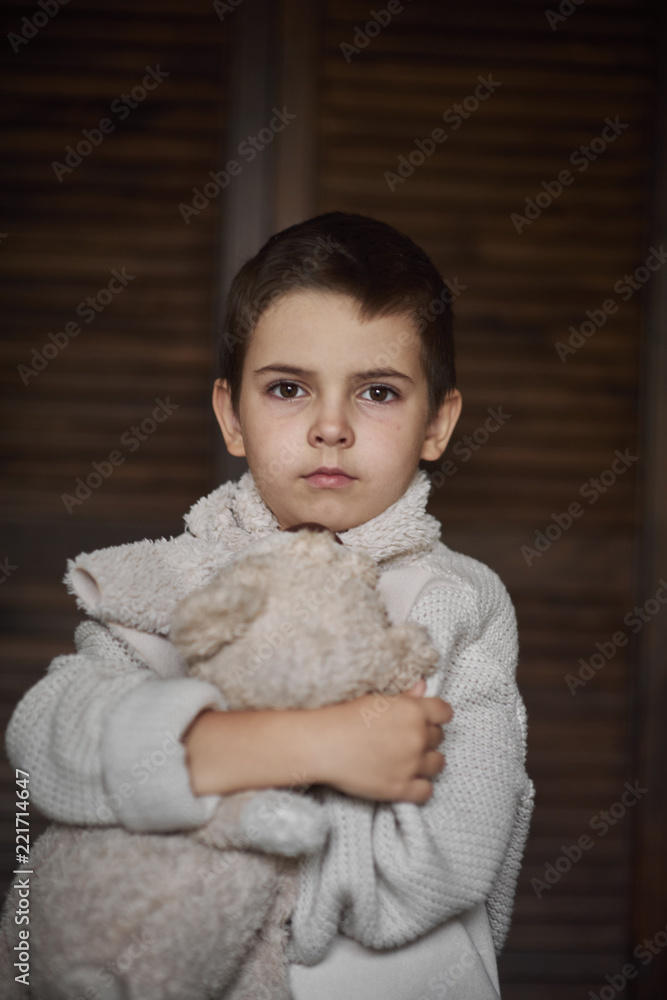 A young boy, a serious look is dressed in a knitted white sweater. Portrait A young boy, a serious look is dressed in a knitted white sweater. Portrait
