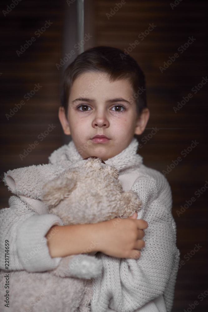 A young boy, a serious look is dressed in a knitted white sweater. Portrait A young boy, a serious look is dressed in a knitted white sweater. Portrait