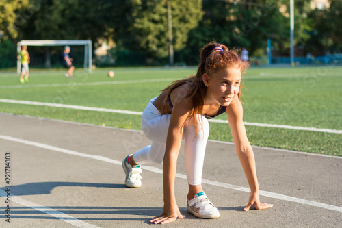 Teenage girl at the start for running in the stadium