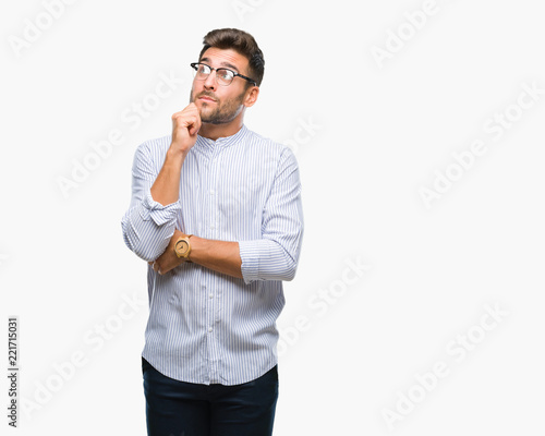 Young handsome man over isolated background with hand on chin thinking about question, pensive expression. Smiling with thoughtful face. Doubt concept.