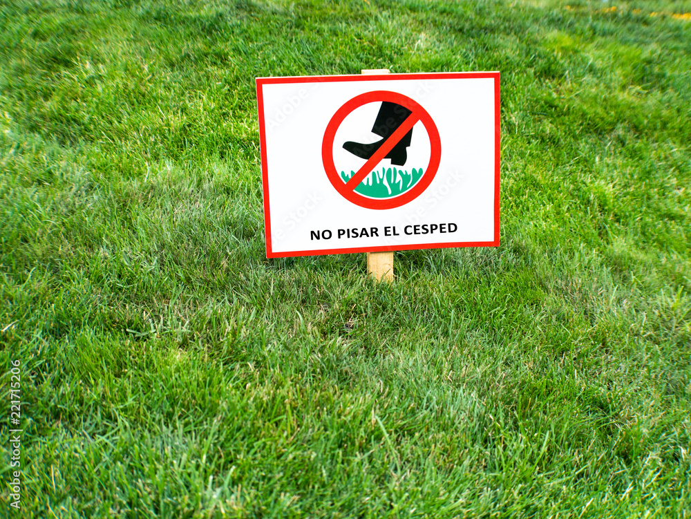 Please keep off the lawn sign in Spanish language. NO PISAR EL CESPED. Stock Photo Adobe Stock