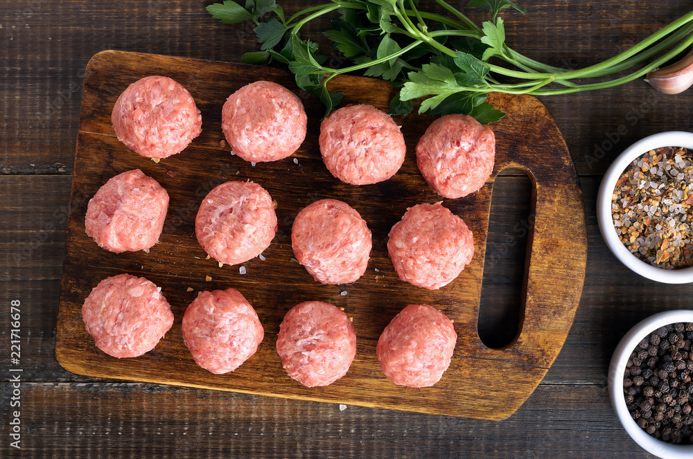 Raw meatballs on a cutting board Raw meatballs on a cutting board