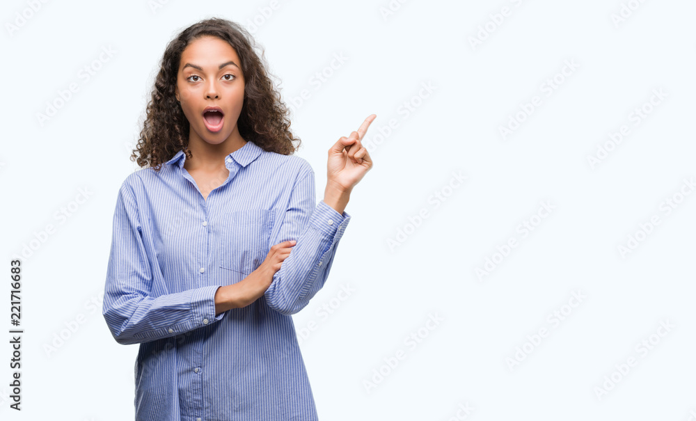 Young hispanic business woman with a big smile on face, pointing with hand and finger to the side looking at the camera. Young hispanic business woman with a big smile on face, pointing with hand and finger to the side looking at the camera.