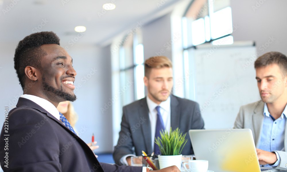 Business people in discussing something while sitting together at the table. Business people in discussing something while sitting together at the table.