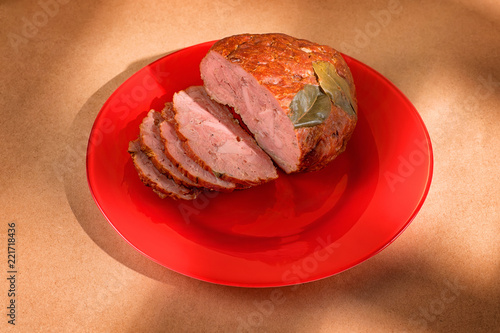 Sliced ham on a red plate