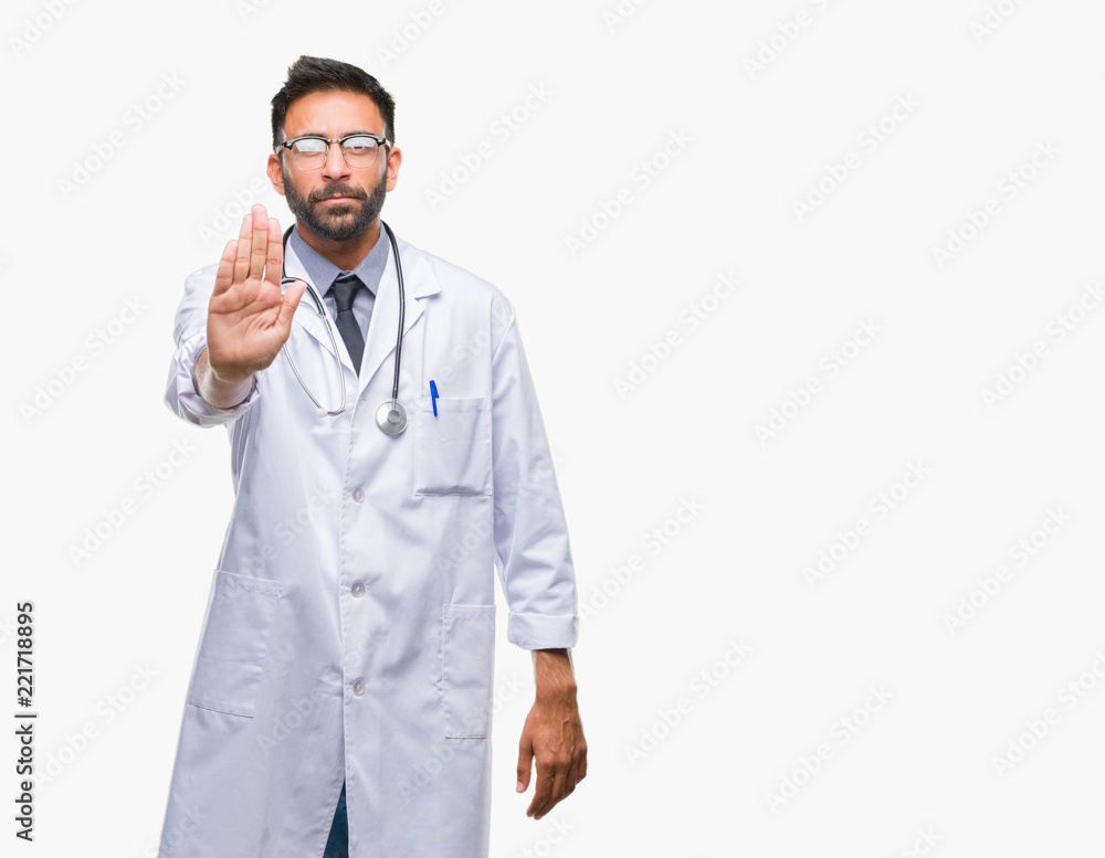 Adult hispanic doctor man over isolated background doing stop sing with palm of the hand. Warning expression with negative and serious gesture on the face.