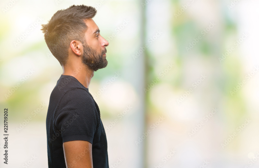 Adult hispanic man over isolated background looking to side, relax profile pose with natural face with confident smile. Adult hispanic man over isolated background looking to side, relax profile pose with natural face with confident smile.
