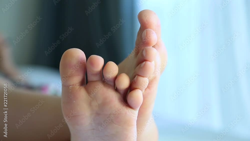 Closeup view video of cute happy young kid of school age playing computer games using smartphone while laying in bed in morning. Focus at two white male preteen barefoot feet. Boy moving his toes. Stock ビデオ | Adobe Stock