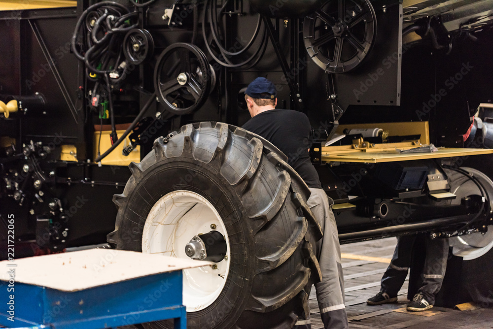 Industrial worker assembles agricultural equipment at plant Industrial worker assembles agricultural equipment at plant