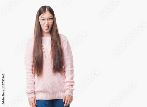 Young Chinese woman over isolated background wearing glasses sticking tongue out happy with funny expression. Emotion concept.