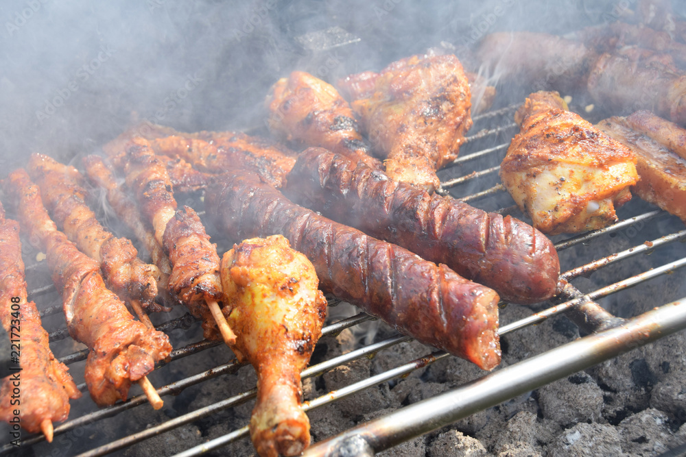 roasted chicken, sausages and skewers on the grill in the smoke roasted chicken, sausages and skewers on the grill in the smoke