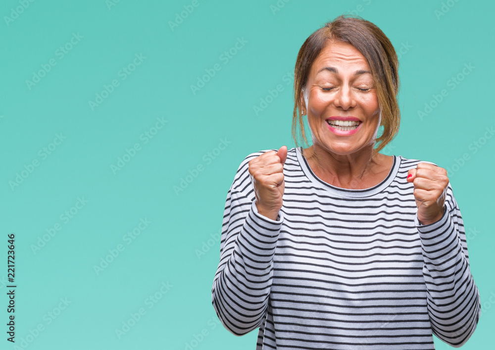 Middle age senior hispanic woman over isolated background excited for success with arms raised celebrating victory smiling. Winner concept. Middle age senior hispanic woman over isolated background excited for success with arms raised celebrating victory smiling. Winner concept.