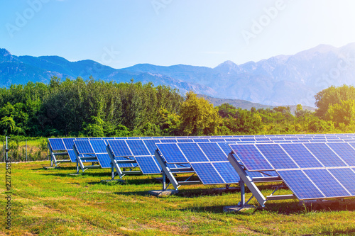 solar panels in field surrounded by mountains